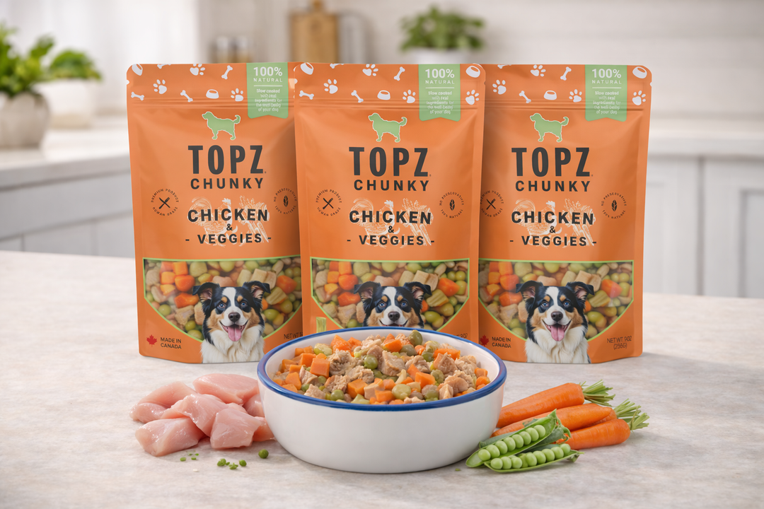Topz Chunky Chicken & Veggies dog food packages with a bowl of food and carrots on a kitchen counter.